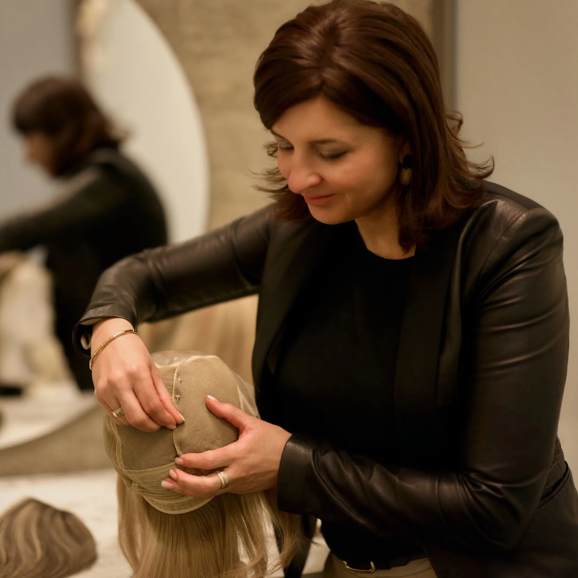 Perückenmacherin passt Haartopper individuell an Kundin an