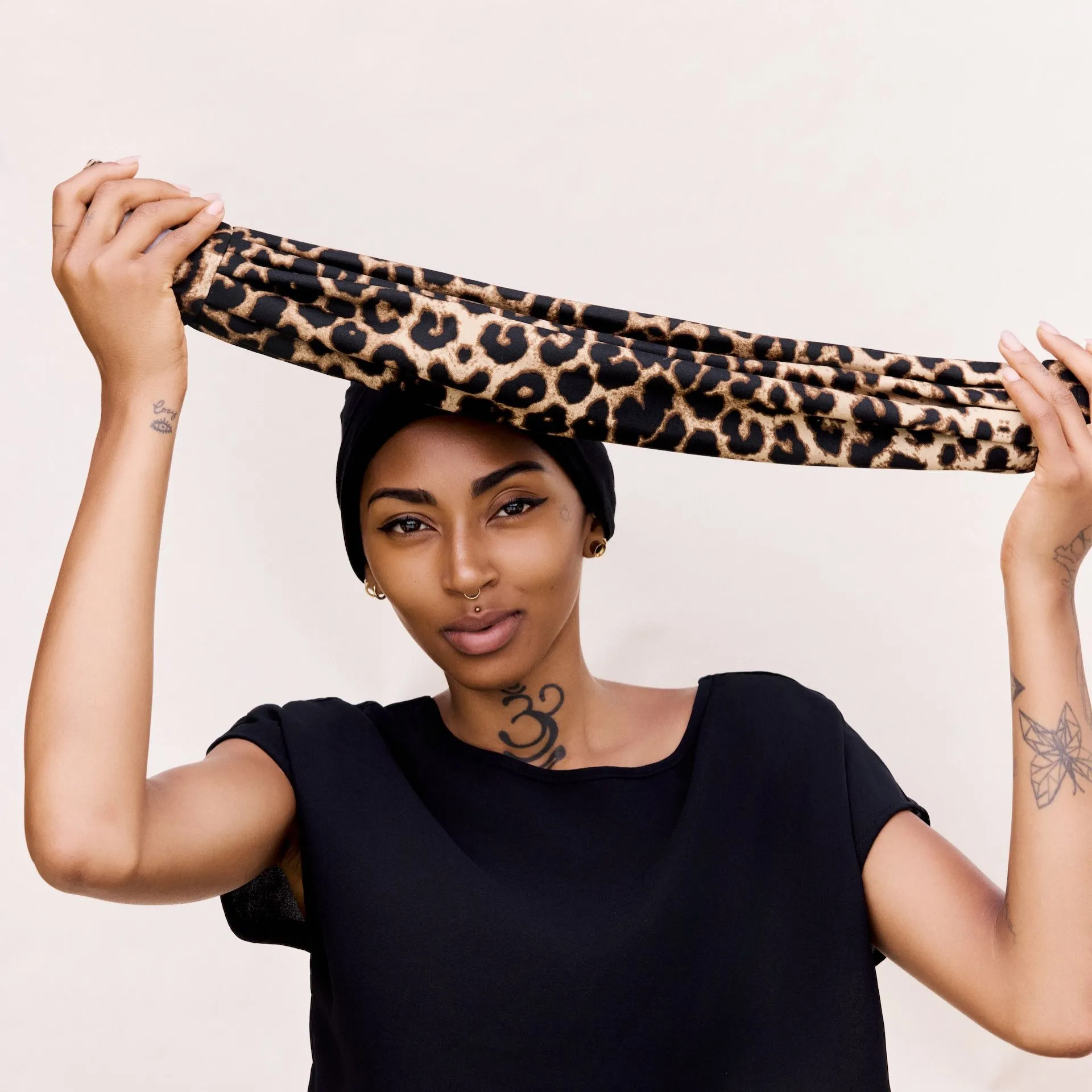 Verschiedene Glückstuch-Modelle in warmen Farbtönen auf einem Holztisch