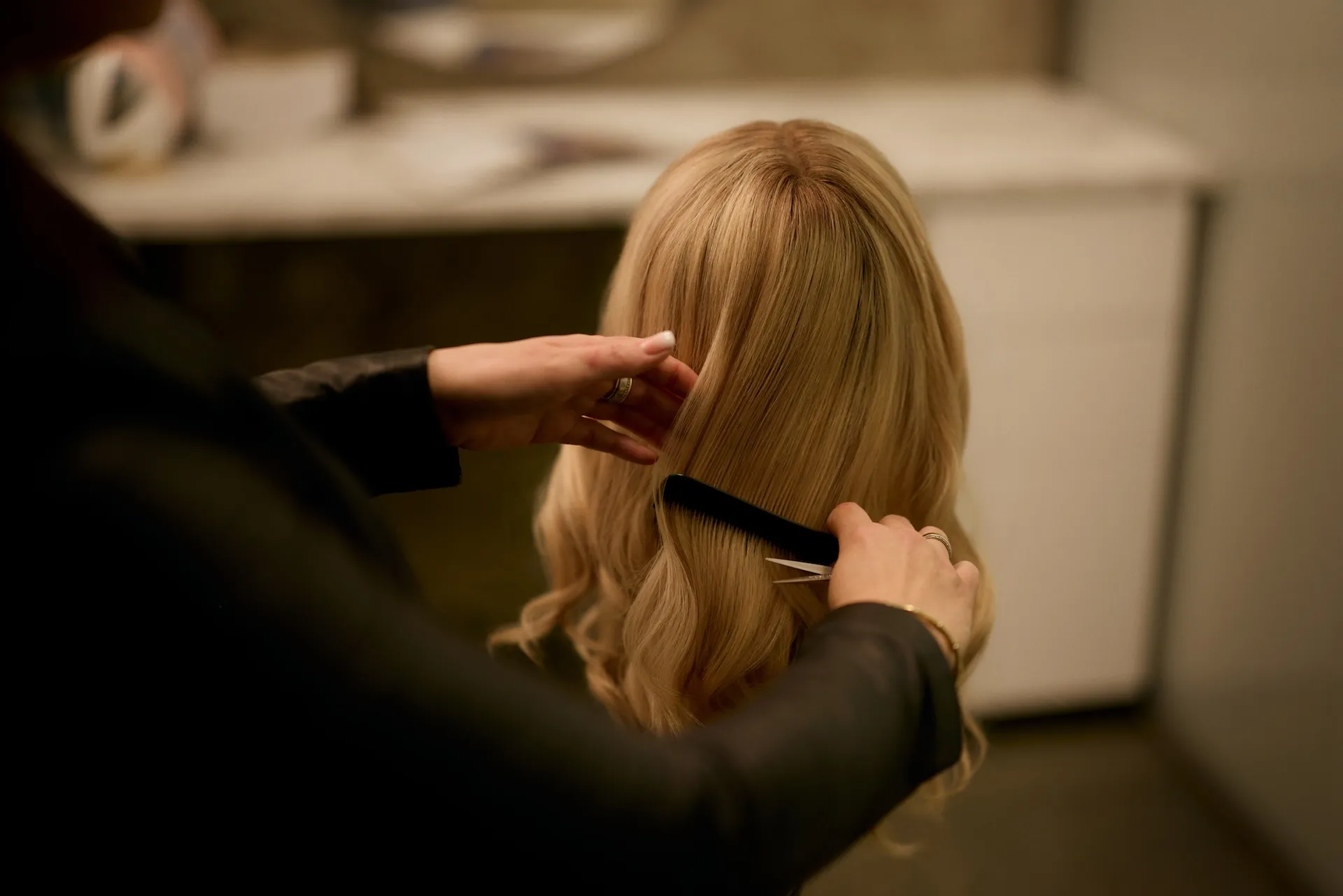 Perückenmacherin bei der handwerklichen Anpassung einer Echthaarperücke